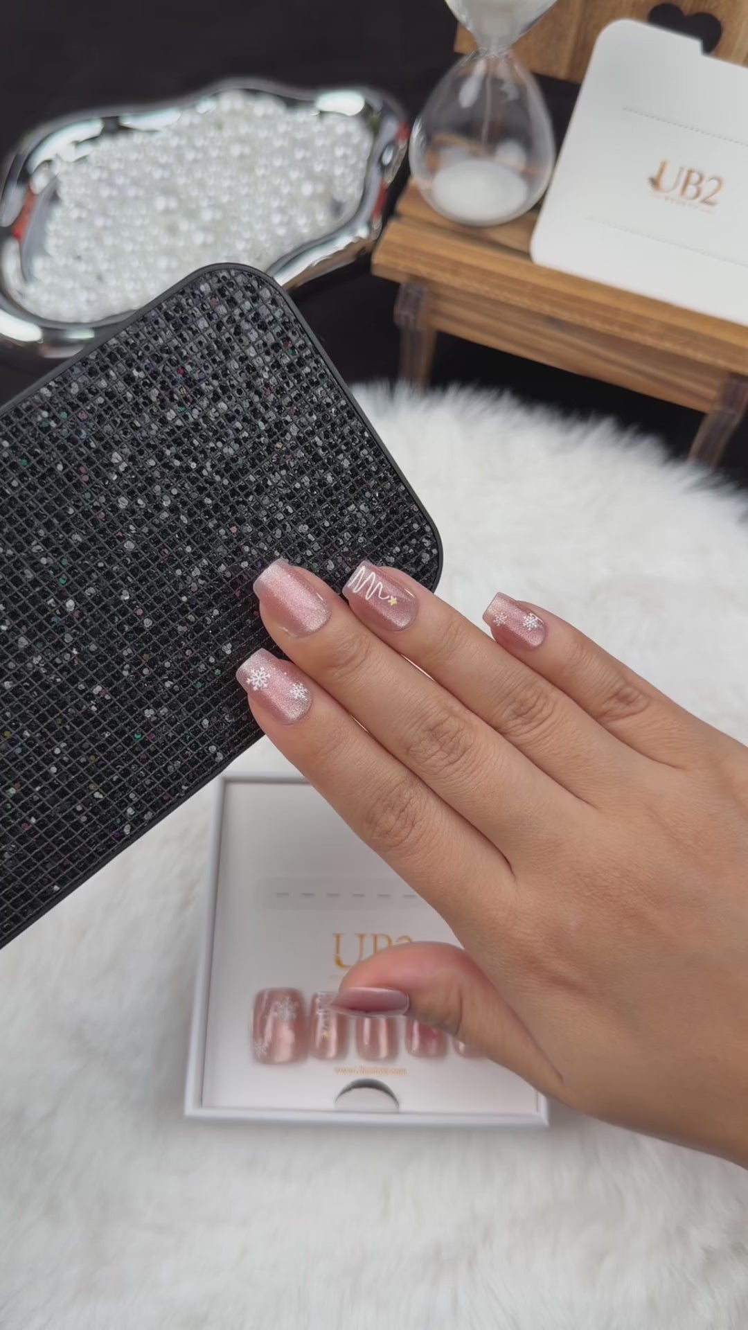 Load video: Step-by-step application of Reindeer Glow rose nude Christmas square press-on nails with silver reindeer and stars