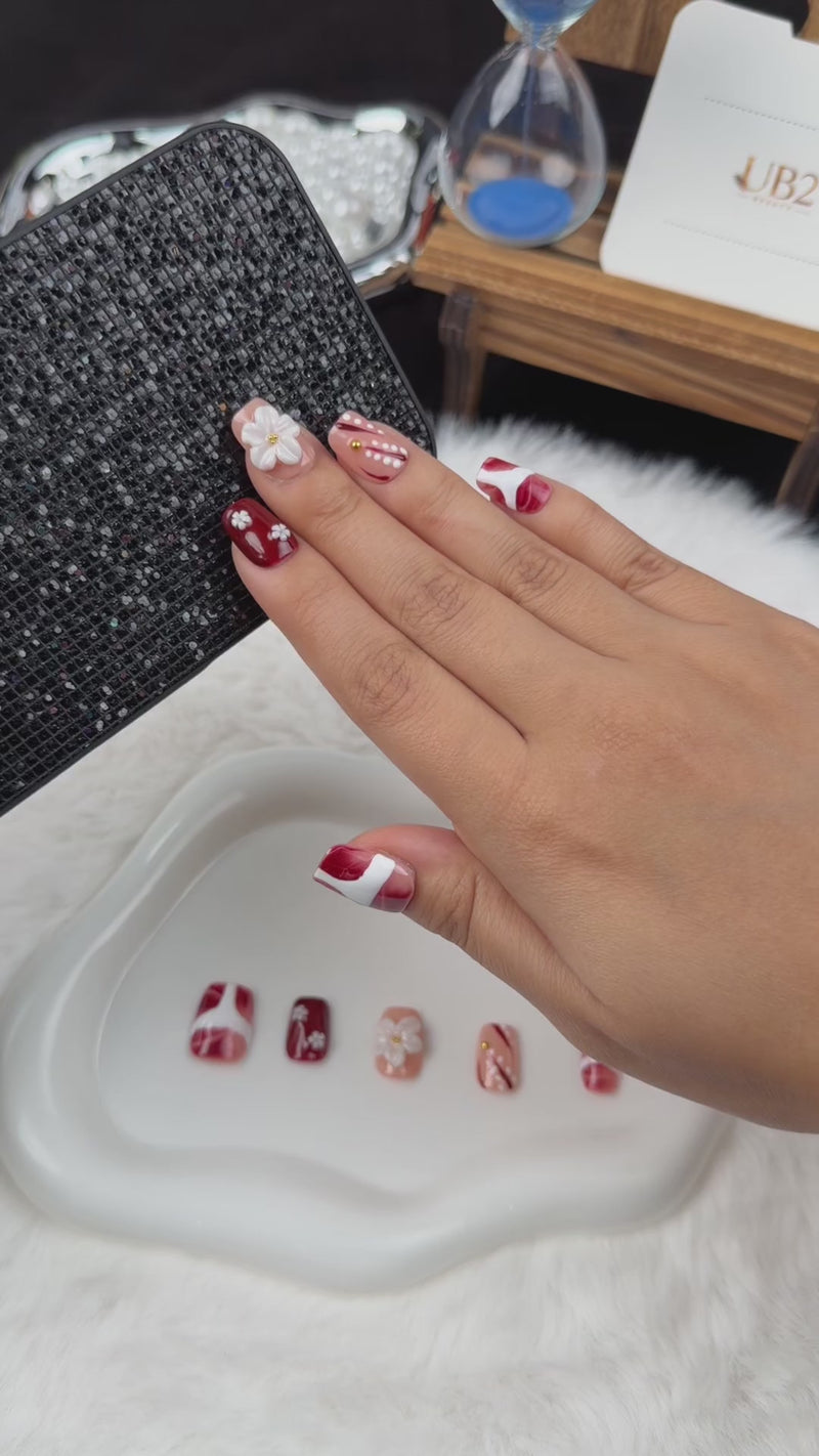 Step-by-step application of Burgundy Blossom burgundy and nude floral square press-on nails with white flowers