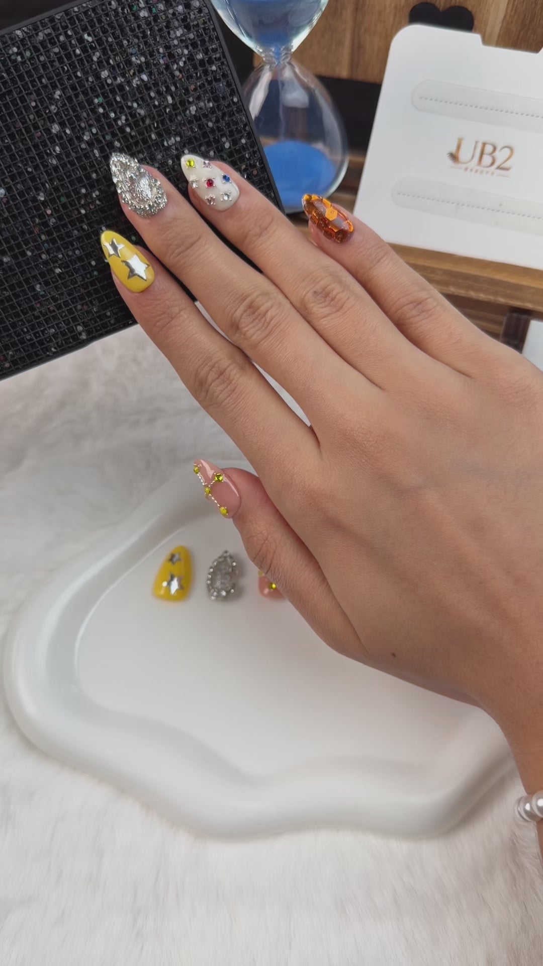 Load video: Step-by-step application of Cosmic Candy Y2K jeweled medium almond press-on nails with celestial details