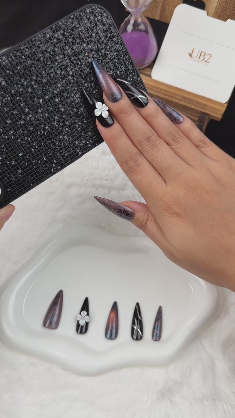 Step-by-step application of Smoky Bloom black and smoky grey stiletto press-on nails with a white 3D flower