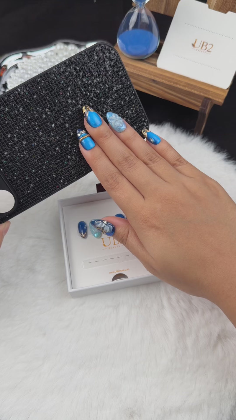 Step-by-step application of Blue Orchid cobalt and aqua floral almond press-on nails with gold lines