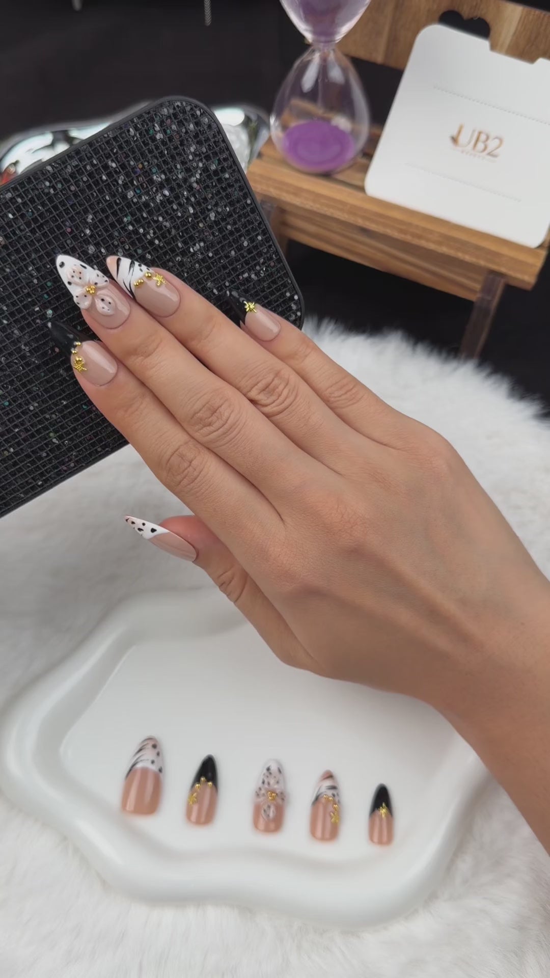 Load video: Step-by-step application of Golden Safari black and white zebra print French tip almond press-on nails with gold accents