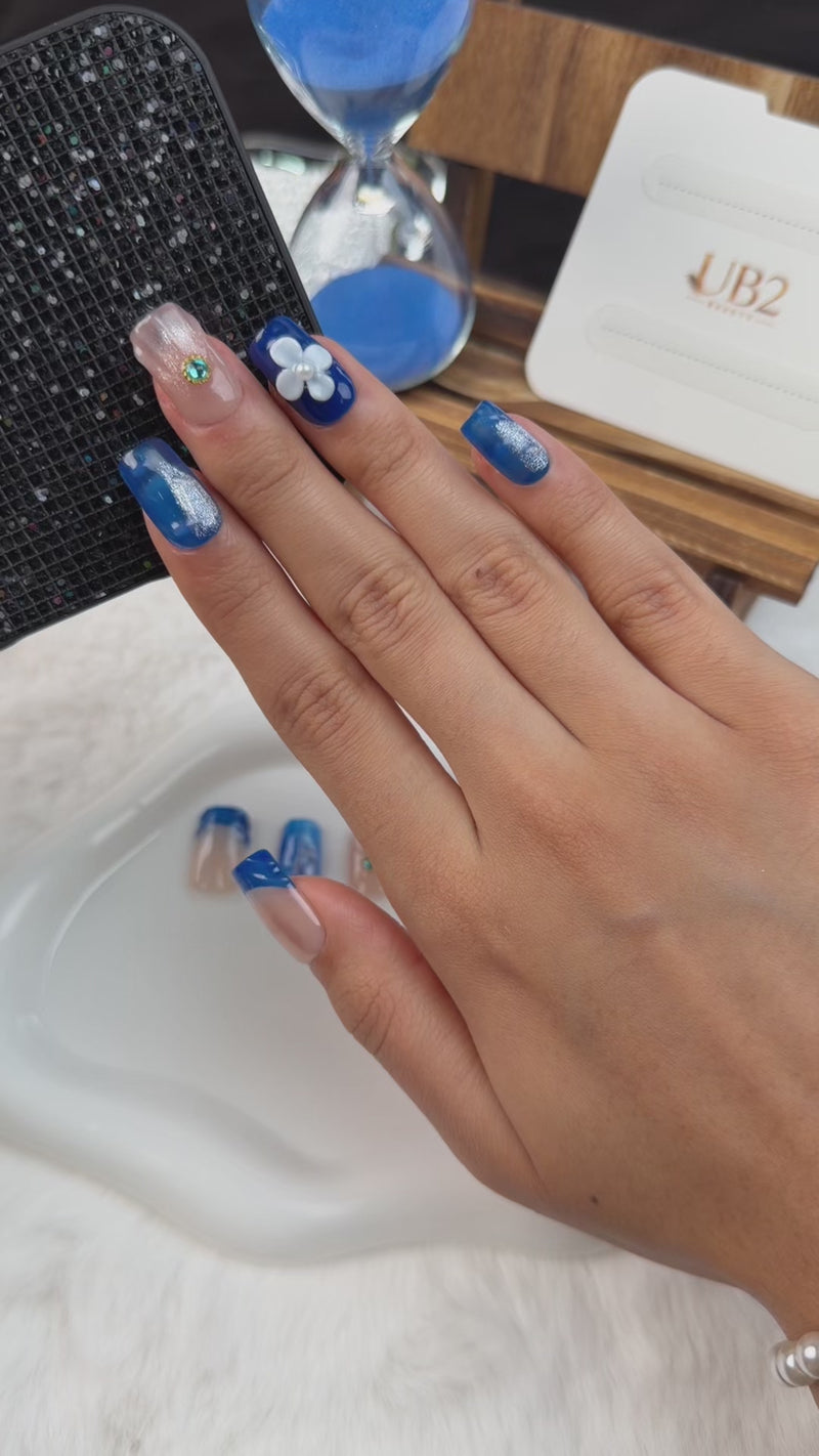 Step-by-step application of Cobalt blue 3D floral medium square press-on nails with white flowers