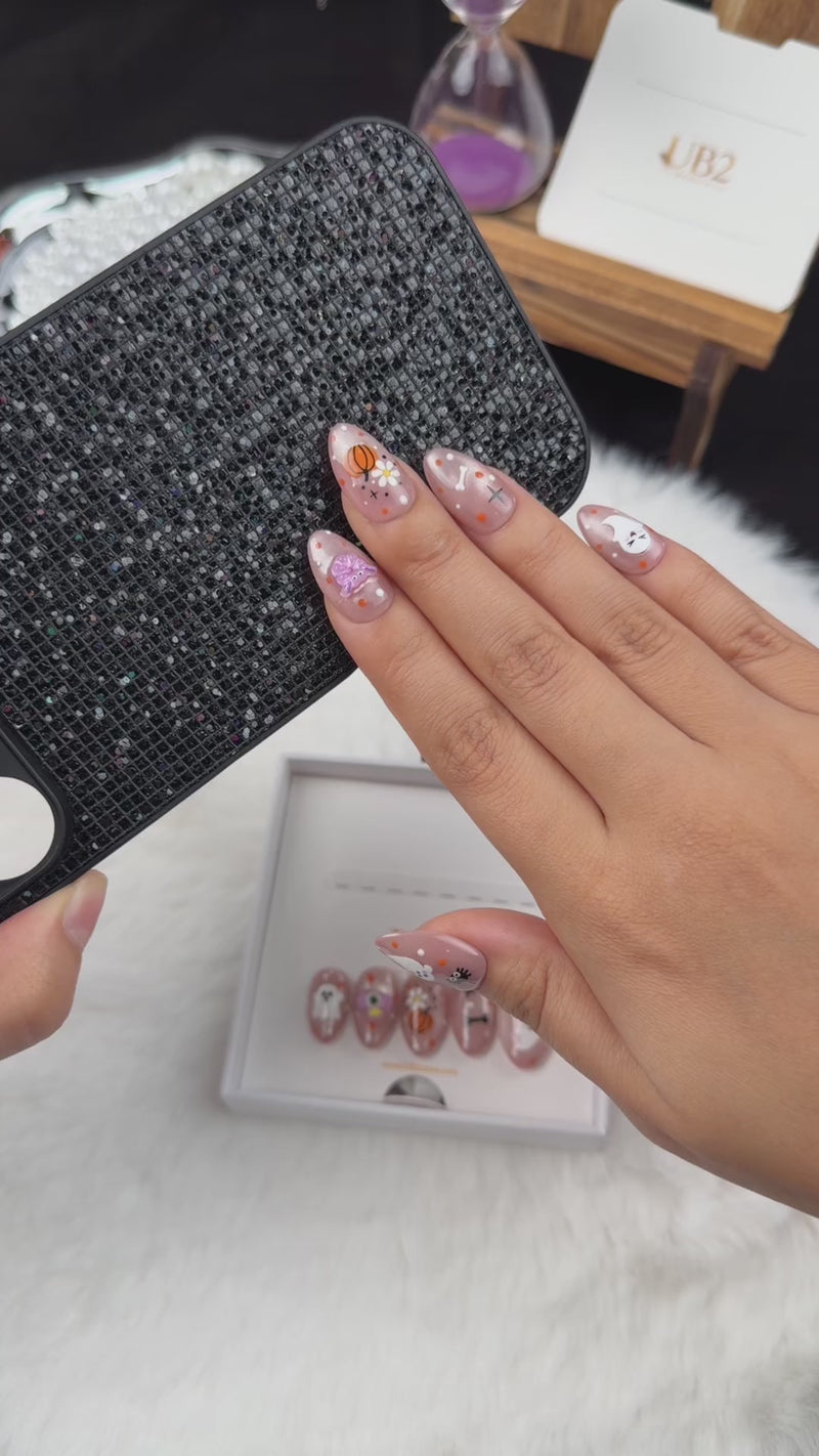 Step-by-step application of Pastel Haunt nude almond press-on nails with cute ghost and pumpkin Halloween designs