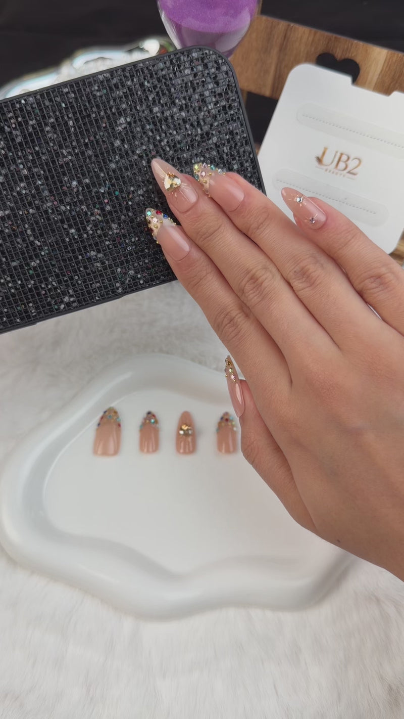 Step-by-step application of Golden Heart peach nude jewel almond press-on nails with a gold heart and crystals