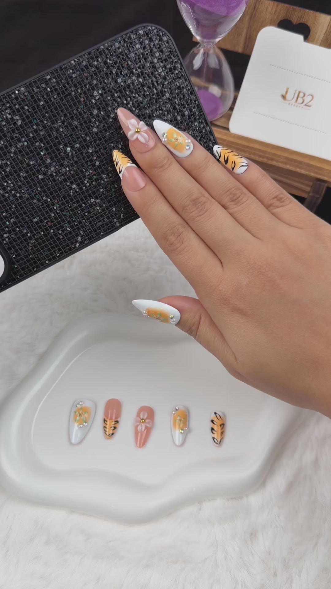 Load video: Step-by-step application of Tiger Lily orange tiger stripe and floral almond press-on nails