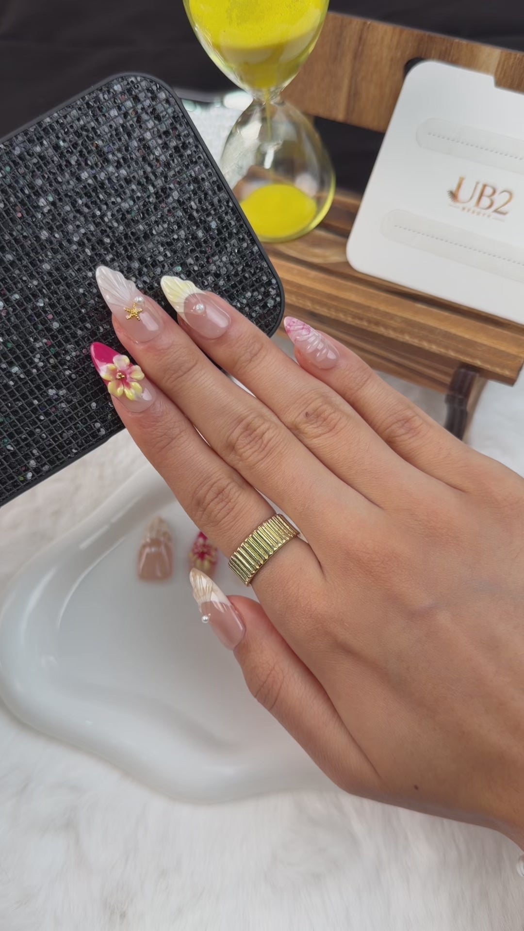 Load video: Step-by-step application of Pink 3D floral seashell medium almond press-on nails with pearls and gold starfish