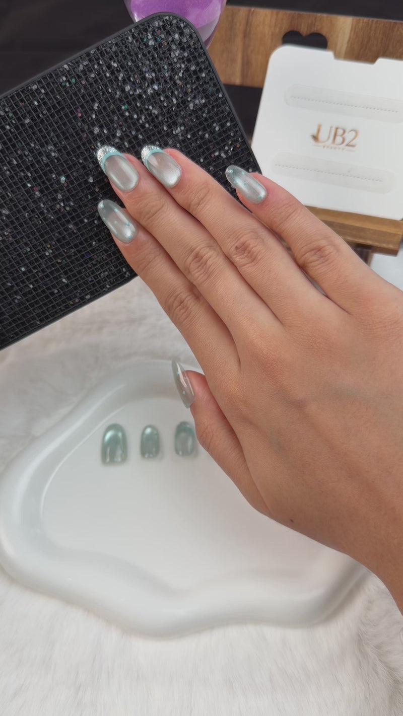 Step-by-step application of Ice Halo icy blue cat eye silver glitter French tip oval press-on nails
