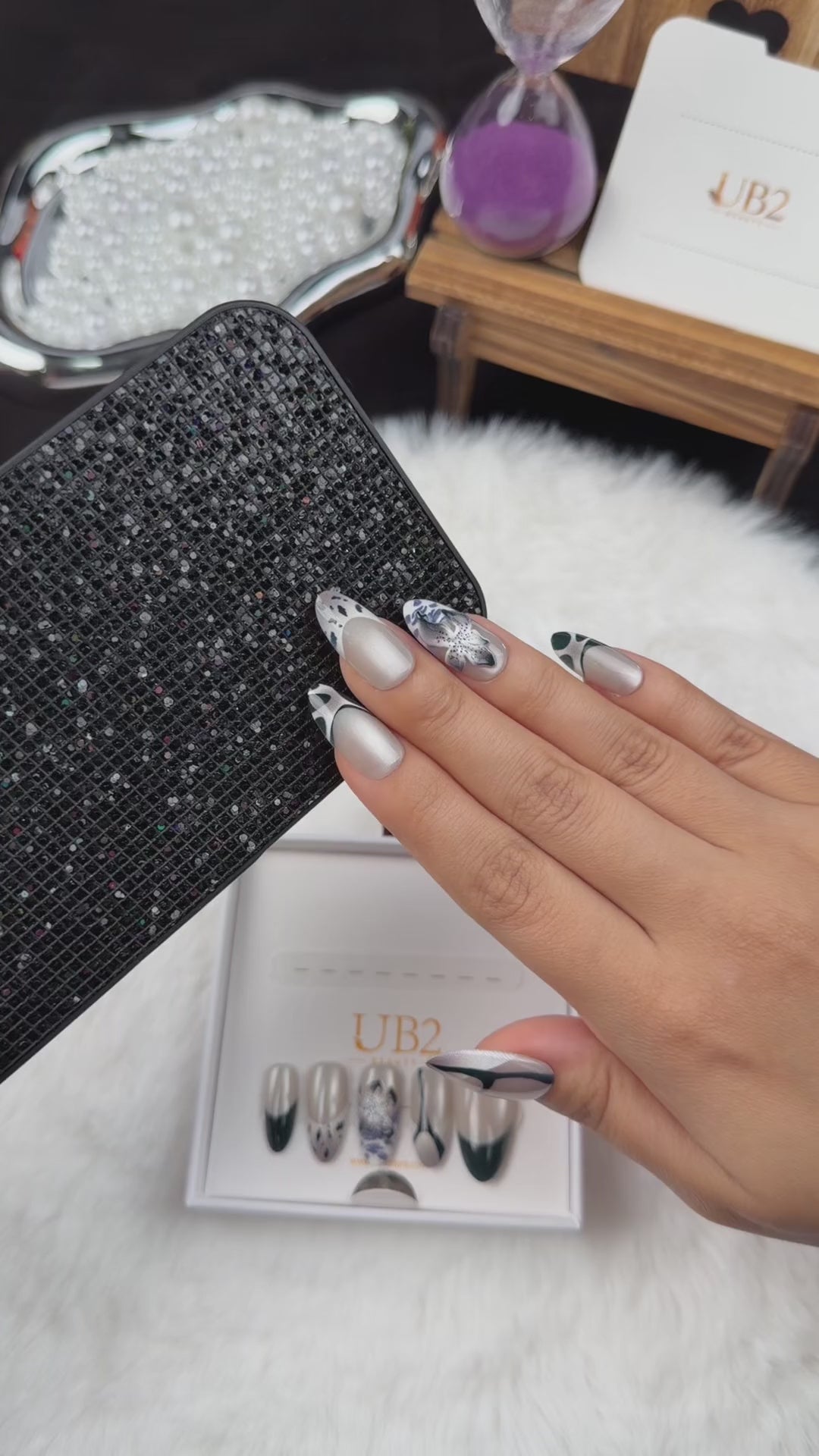 Load video: Step-by-step application of Midnight Iris black French tip and pearl white floral almond press-on nails
