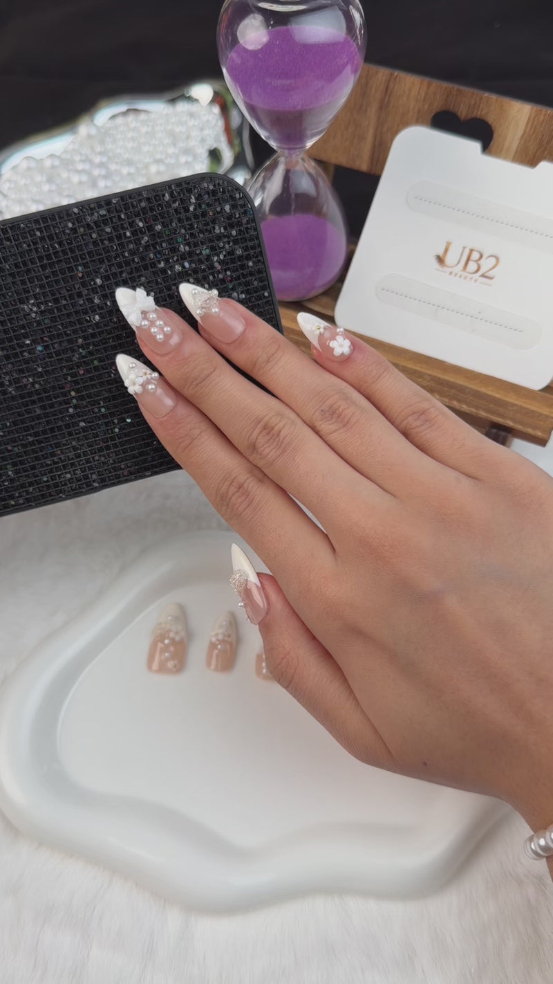 Step-by-step application of Pearl Bouquet white French tip floral pearl medium almond press-on nails with a bow
