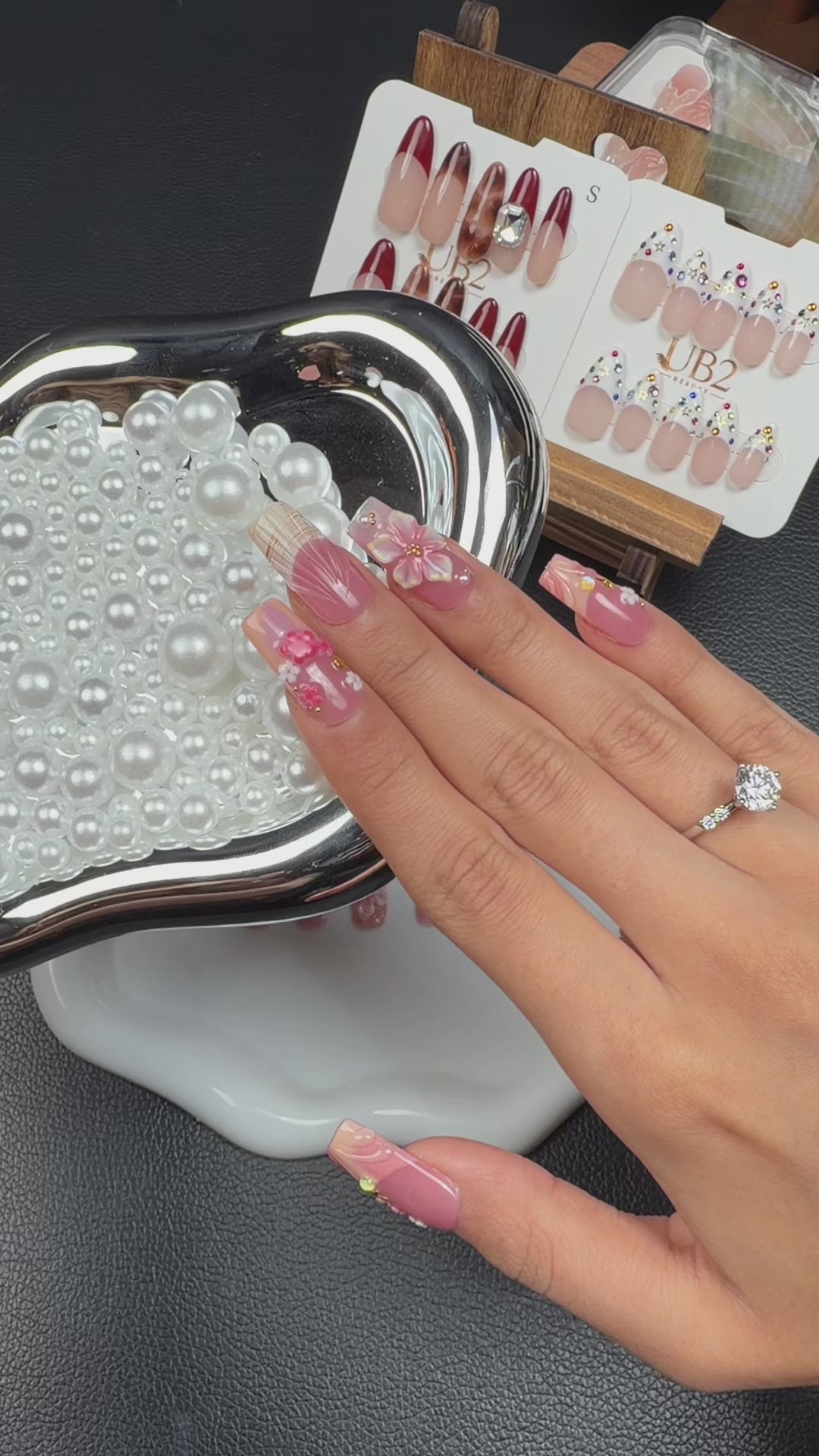 Load video: Step-by-step application of Lily Blush pink 3D floral square press-on nails with pearls and gold accents
