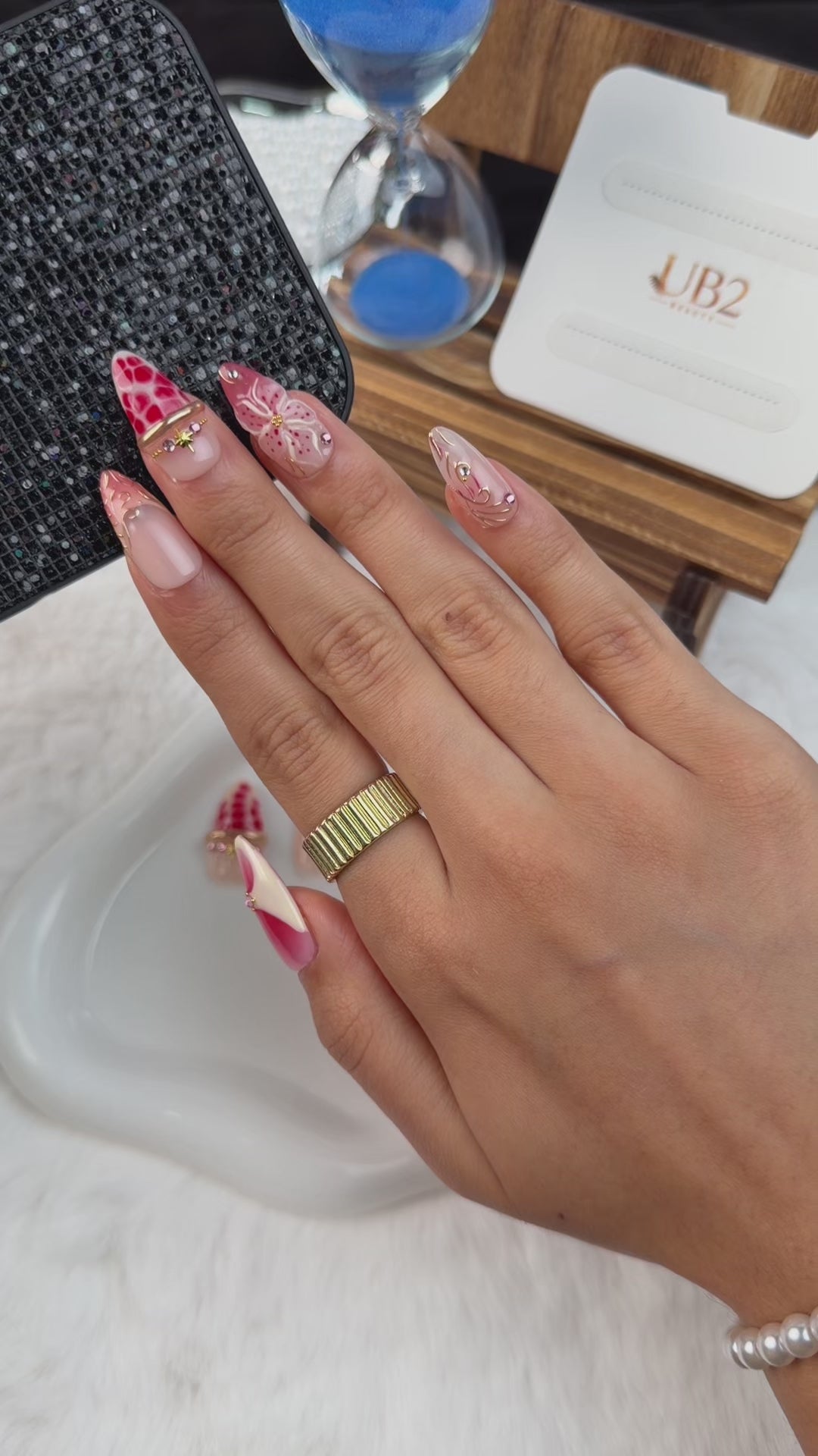Load video: Step-by-step application of Strawberry Bloom nude pink and berry red floral medium almond press-on nails