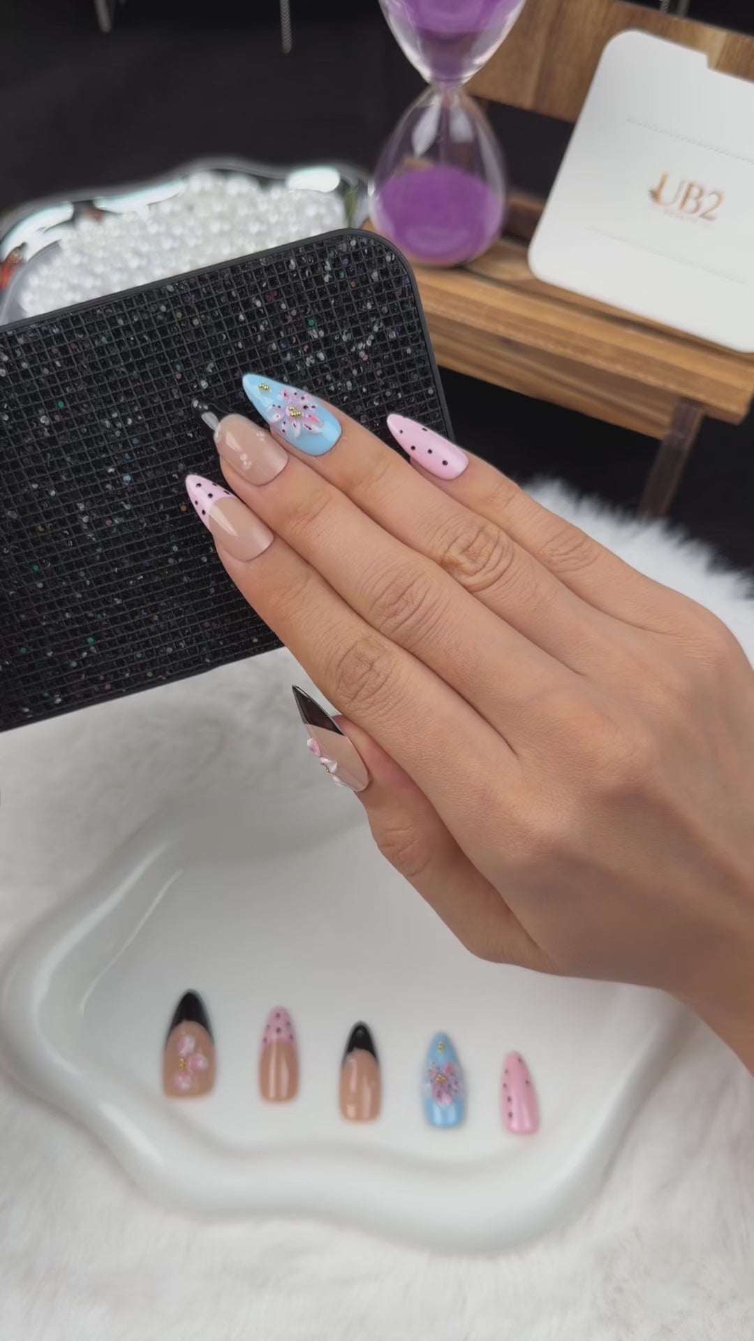 Load video: Step-by-step application of Playful Petals pink, blue and black polka dot floral almond press-on nails