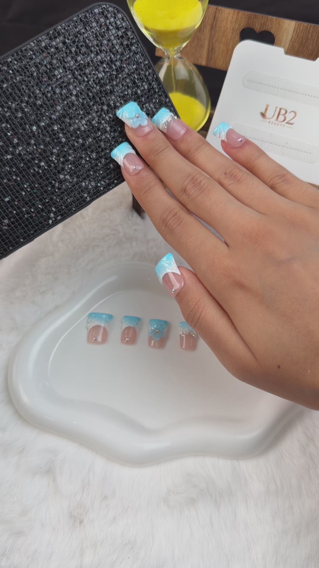 Load video: Step-by-step application of baby blue French tip square press-on nails with a 3D flower and rhinestones