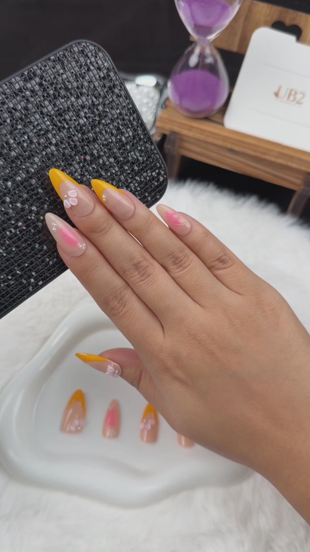 Load video: Step-by-step application of Apricot Petals orange French tip and pink floral almond press-on nails