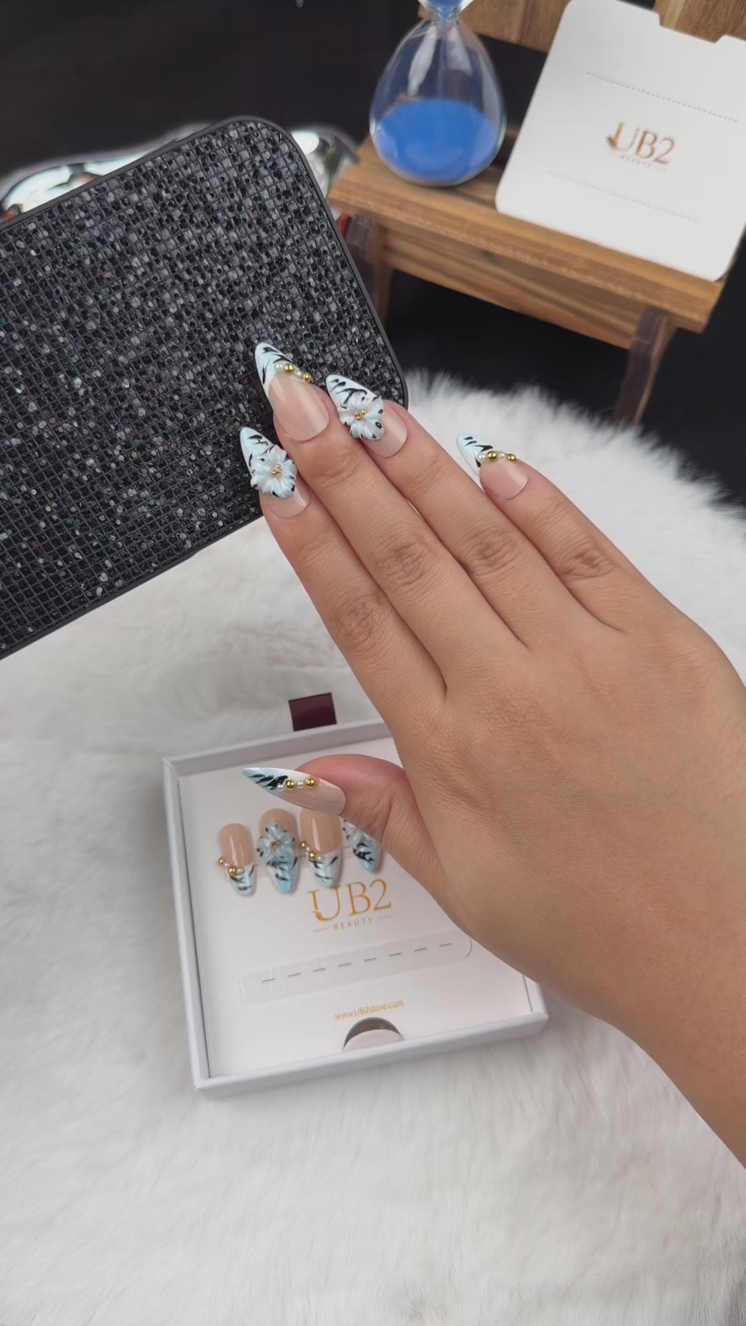 Load video: Step-by-step application of Frost Bloom ice blue striped French tip almond press-on nails with white flowers