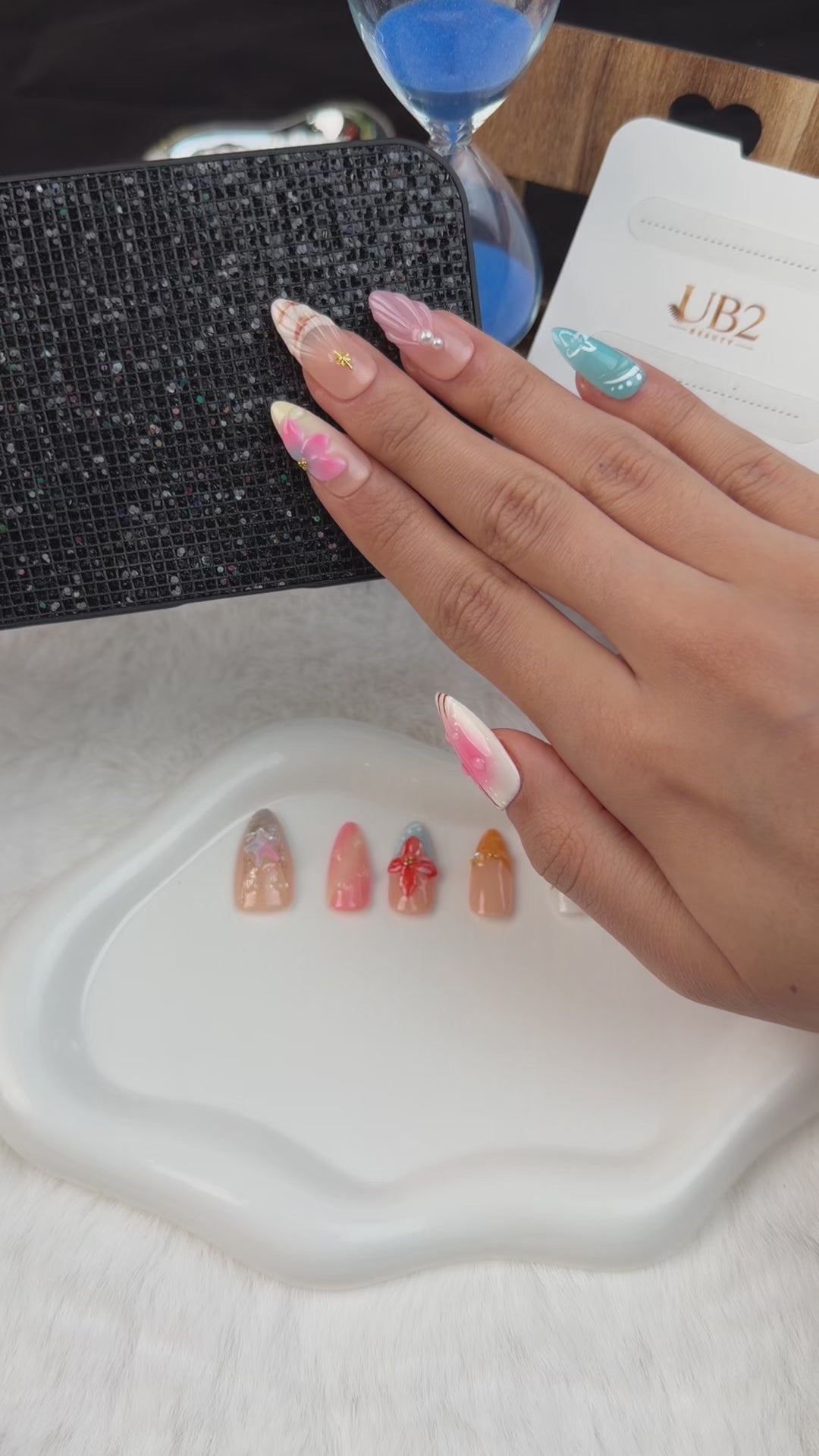 Load video: Step-by-step application of Pastel tropical shell and floral almond press-on nails