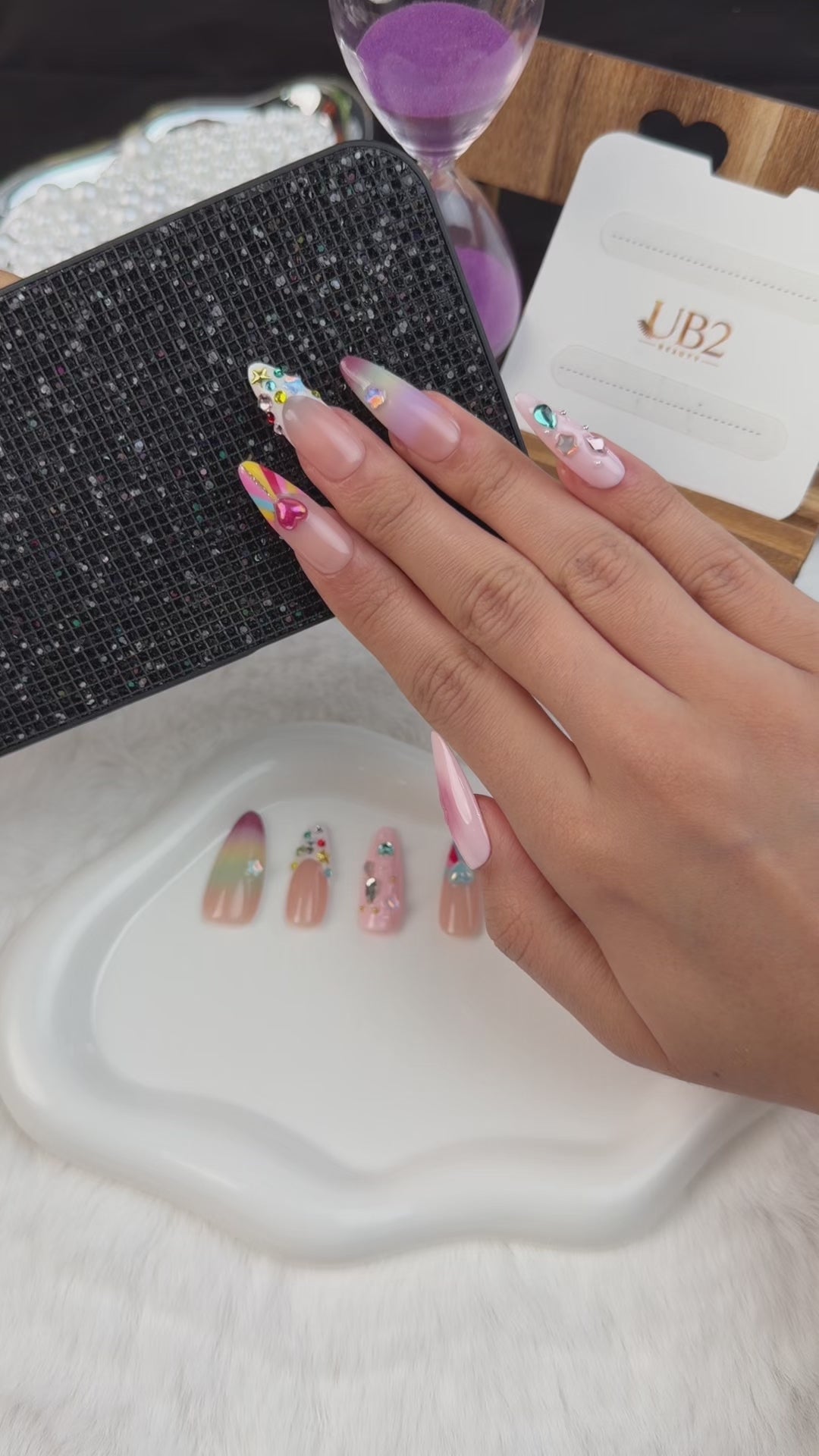 Load video: Step-by-step application of Sugar Pop pastel rainbow crystal heart Y2K medium almond press-on nails