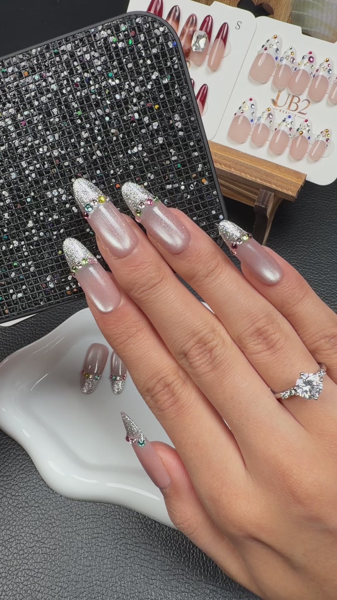 Load video: Step-by-step application of Silver Veil nude pink and silver French tip medium oval press-on nails with rhinestones