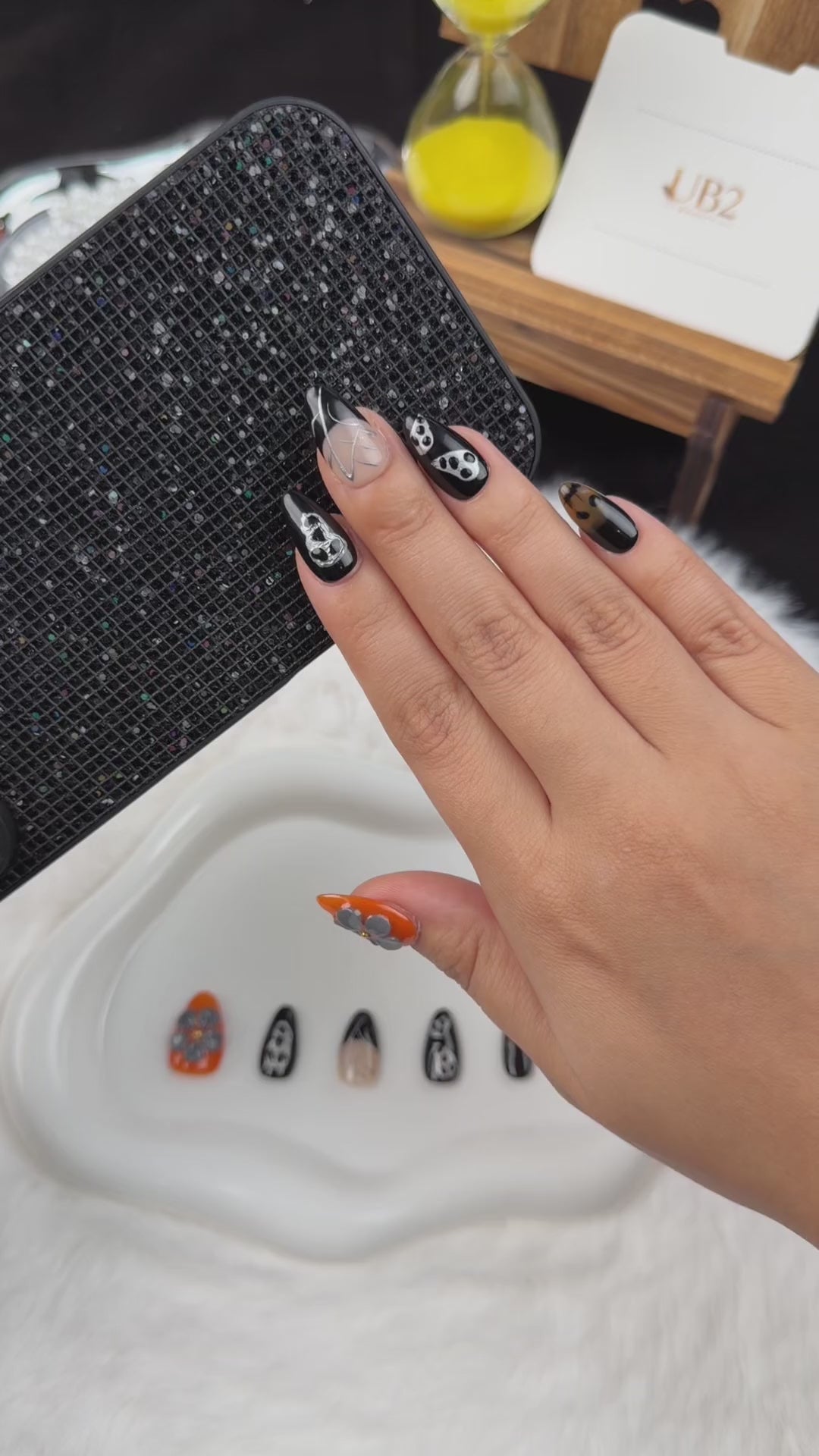 Load video: Step-by-step application of Midnight Web black and orange skull and spiderweb almond press-on nails