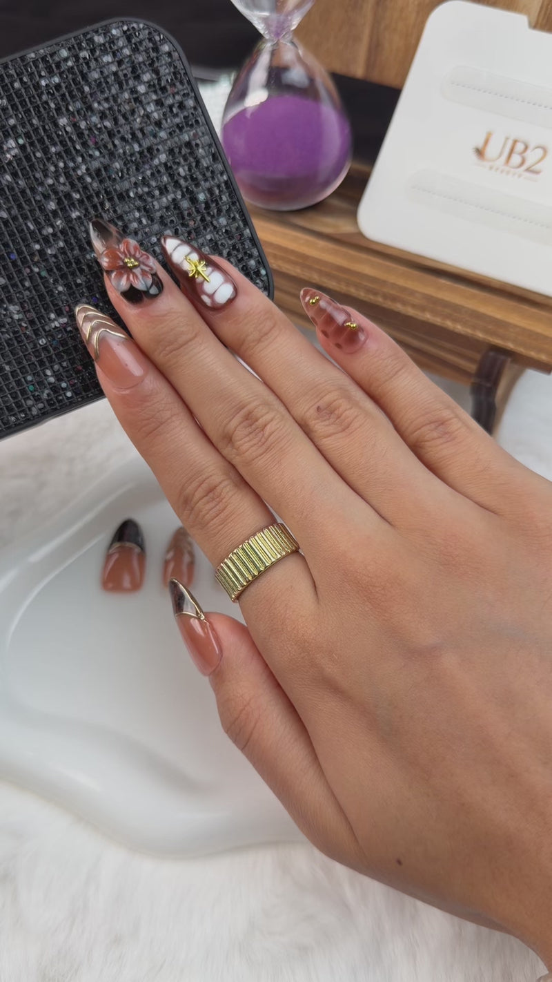 Step-by-step application of Amber tortoiseshell floral French tip almond press-on nails with gold details