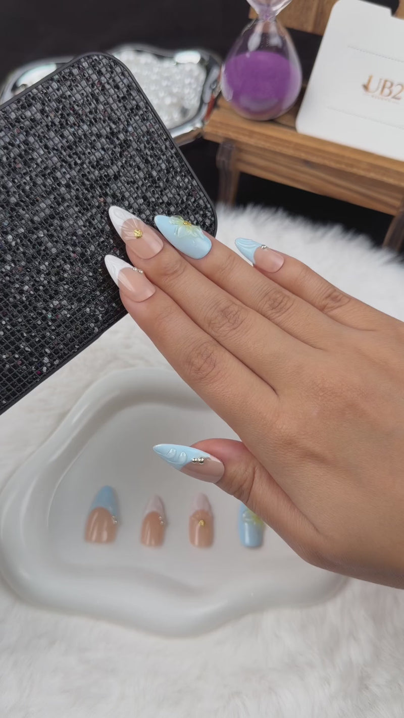 Step-by-step application of Seaside Petals light blue and nude shell floral almond press-on nails