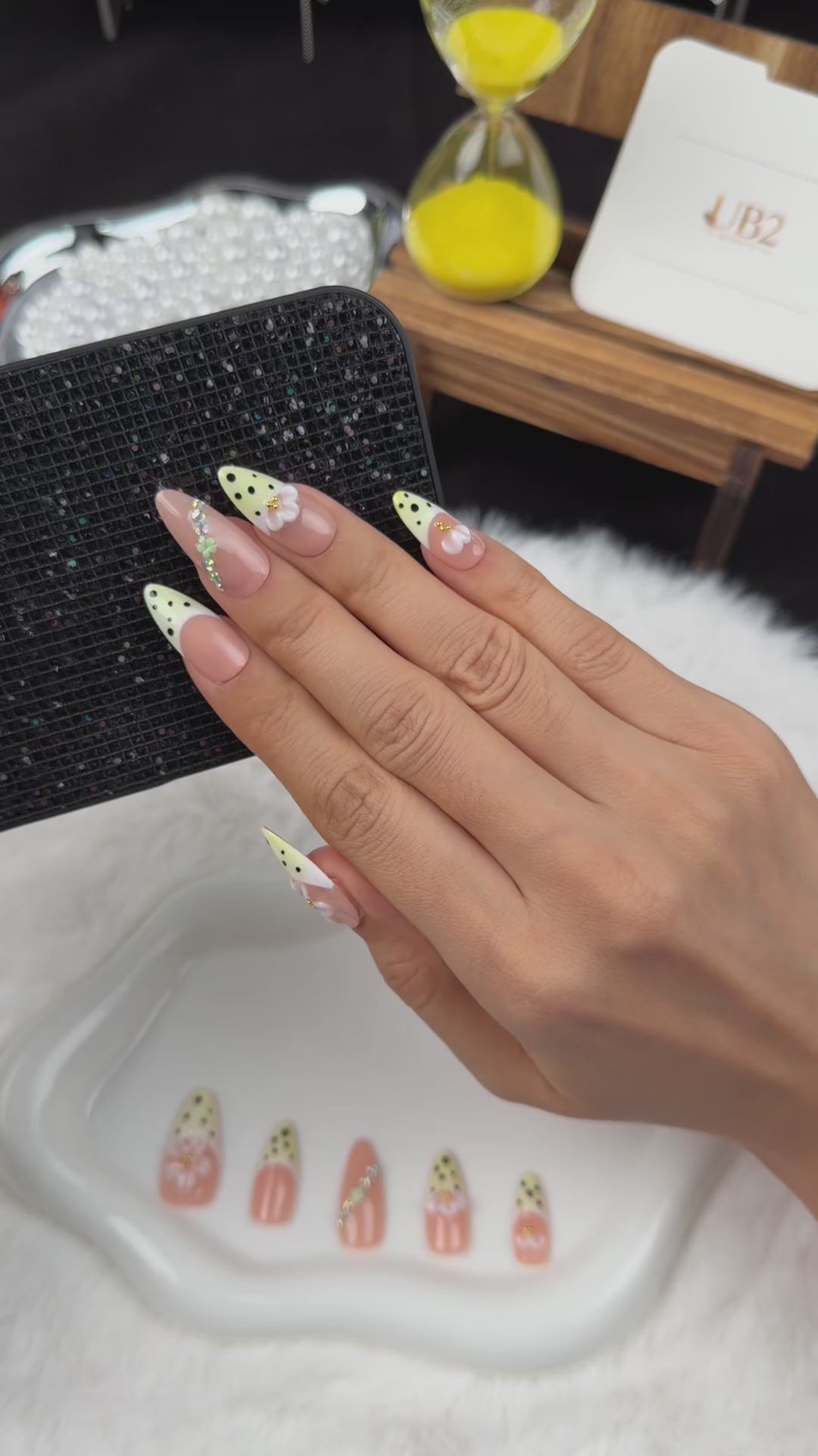 Load video: Step-by-step application of Lemon Blossom yellow polka dot French tip floral almond press-on nails